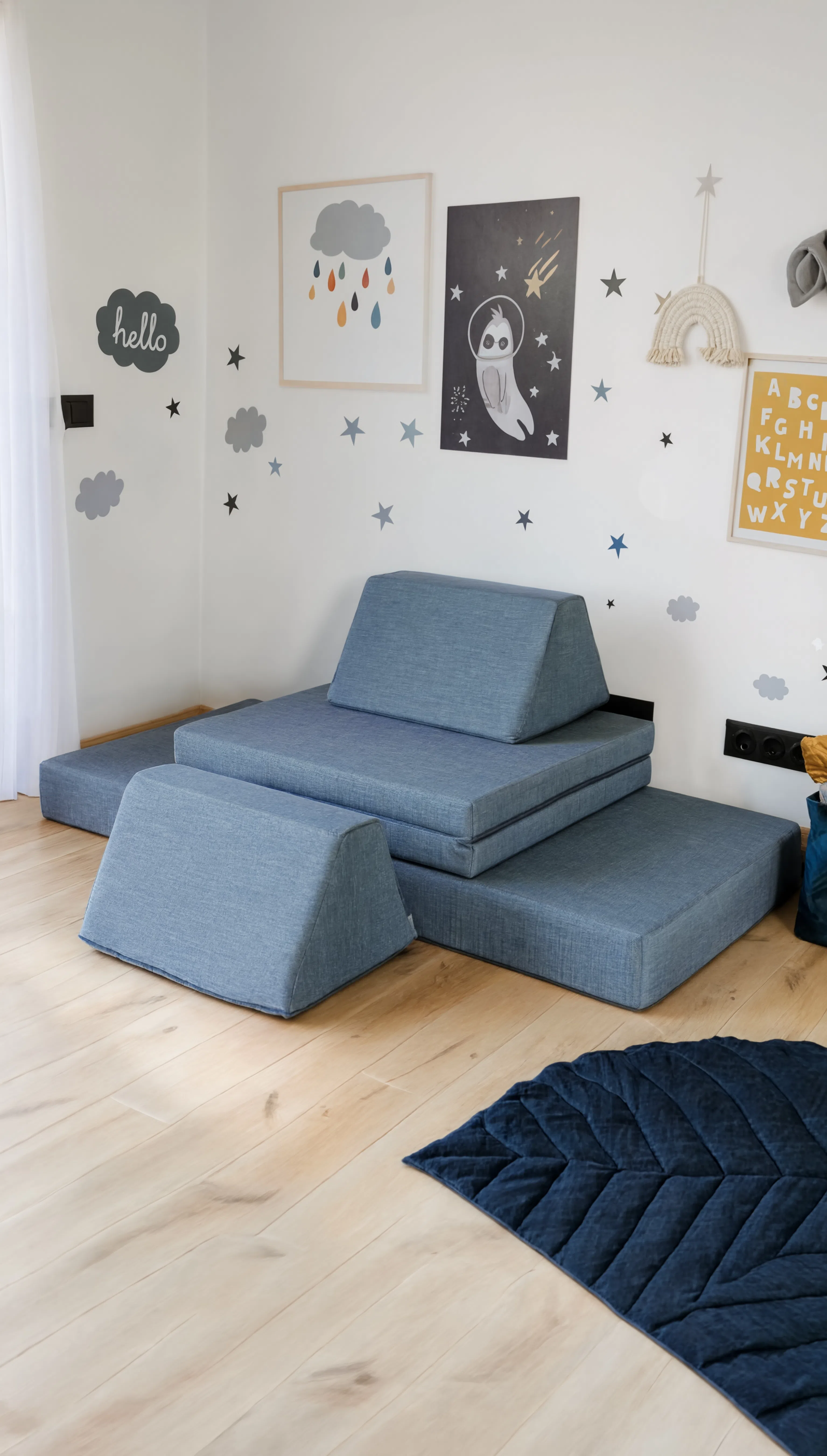 Blue wedge cushions arranged on a wooden floor with decorative wall art in the background.
