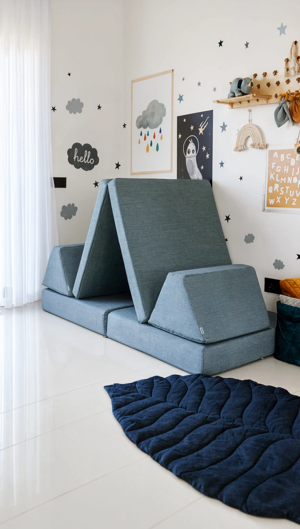 Children's room with a blue foam wedge on the floor and wall decorations.