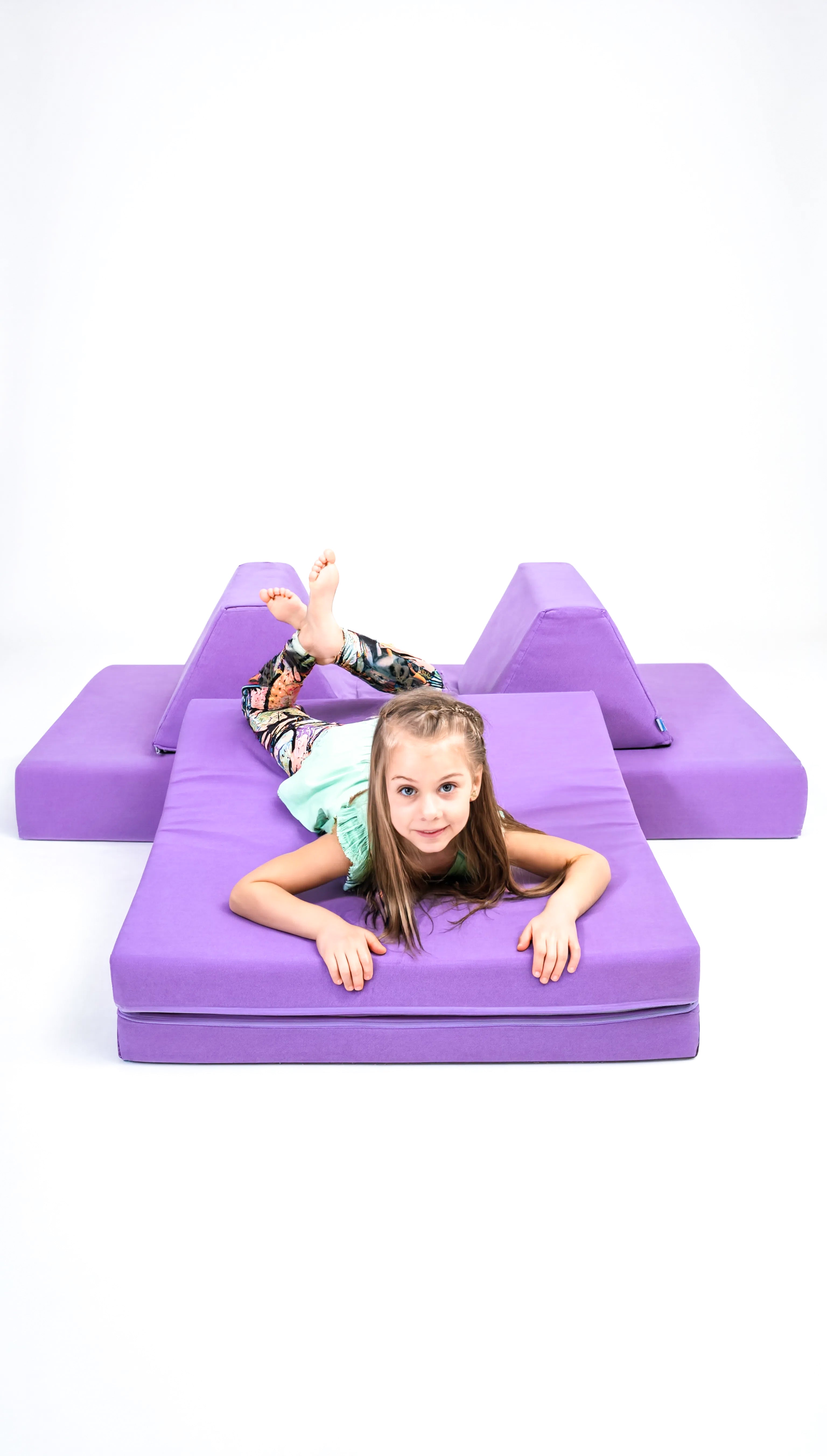 Child playing on a purple foam play set against a white background