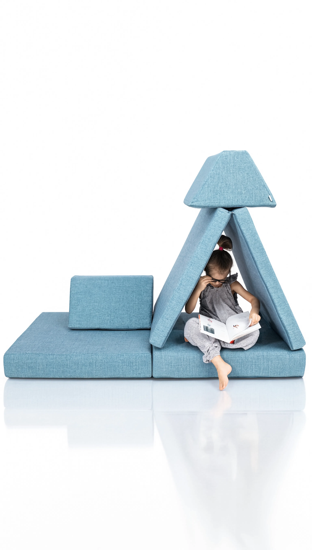 Child playing with a toy inside a blue geometric playhouse on a white background