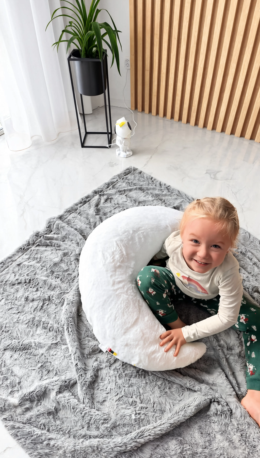Child playing inside a large white plush toy on a gray rug.