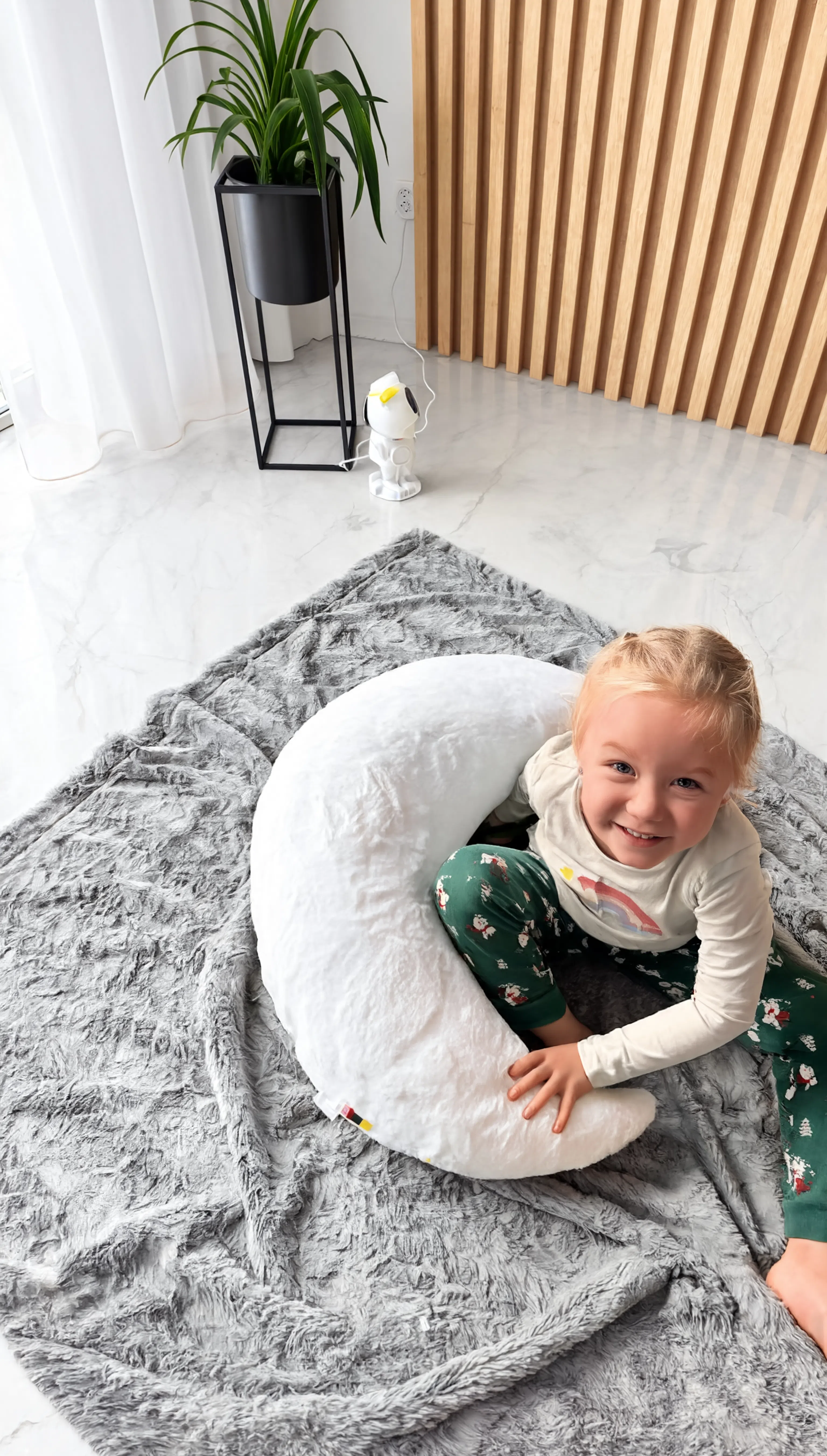 Child playing inside a large white plush toy on a gray rug.