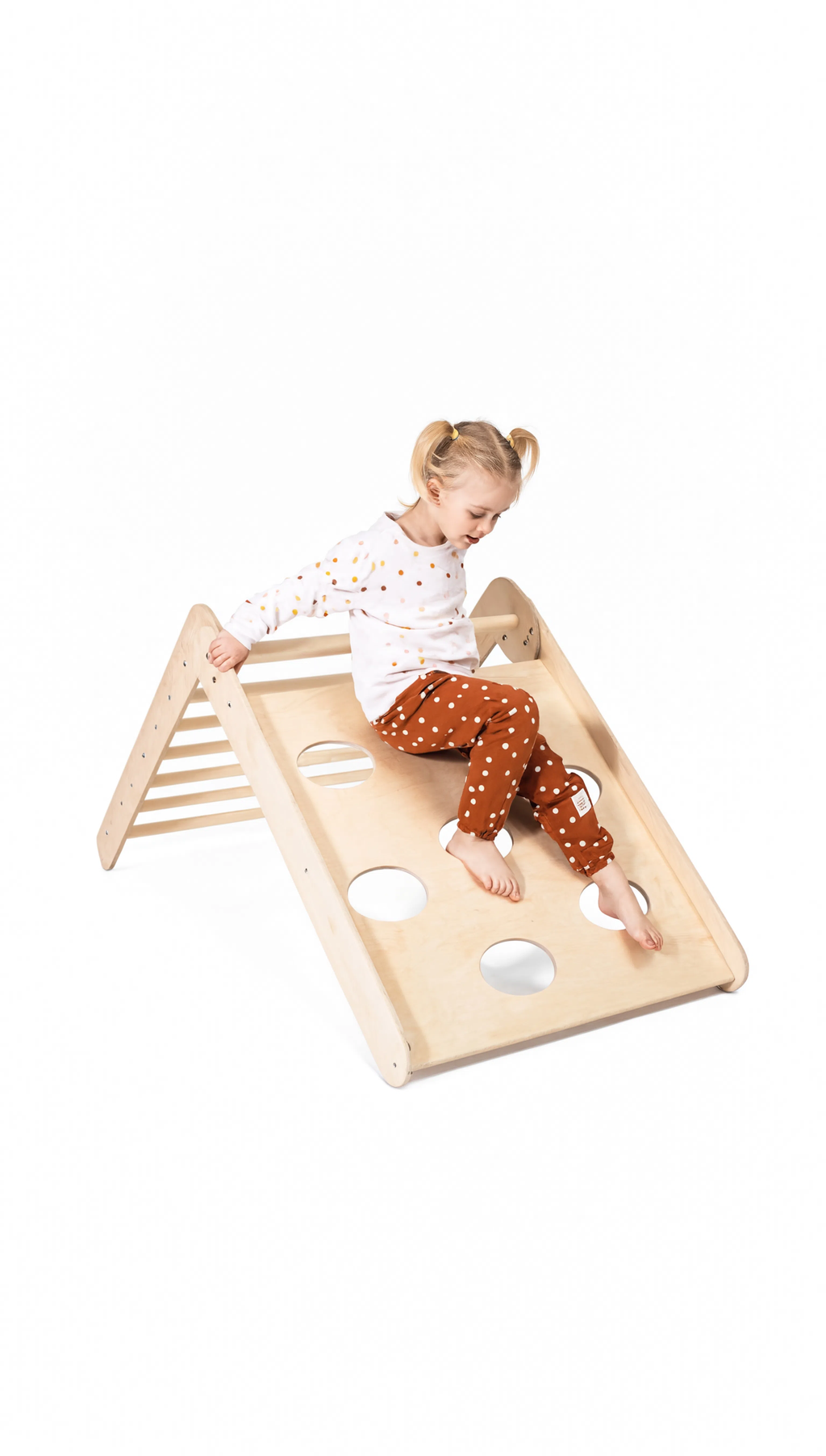 Child playing on a wooden climbing toy with a white background