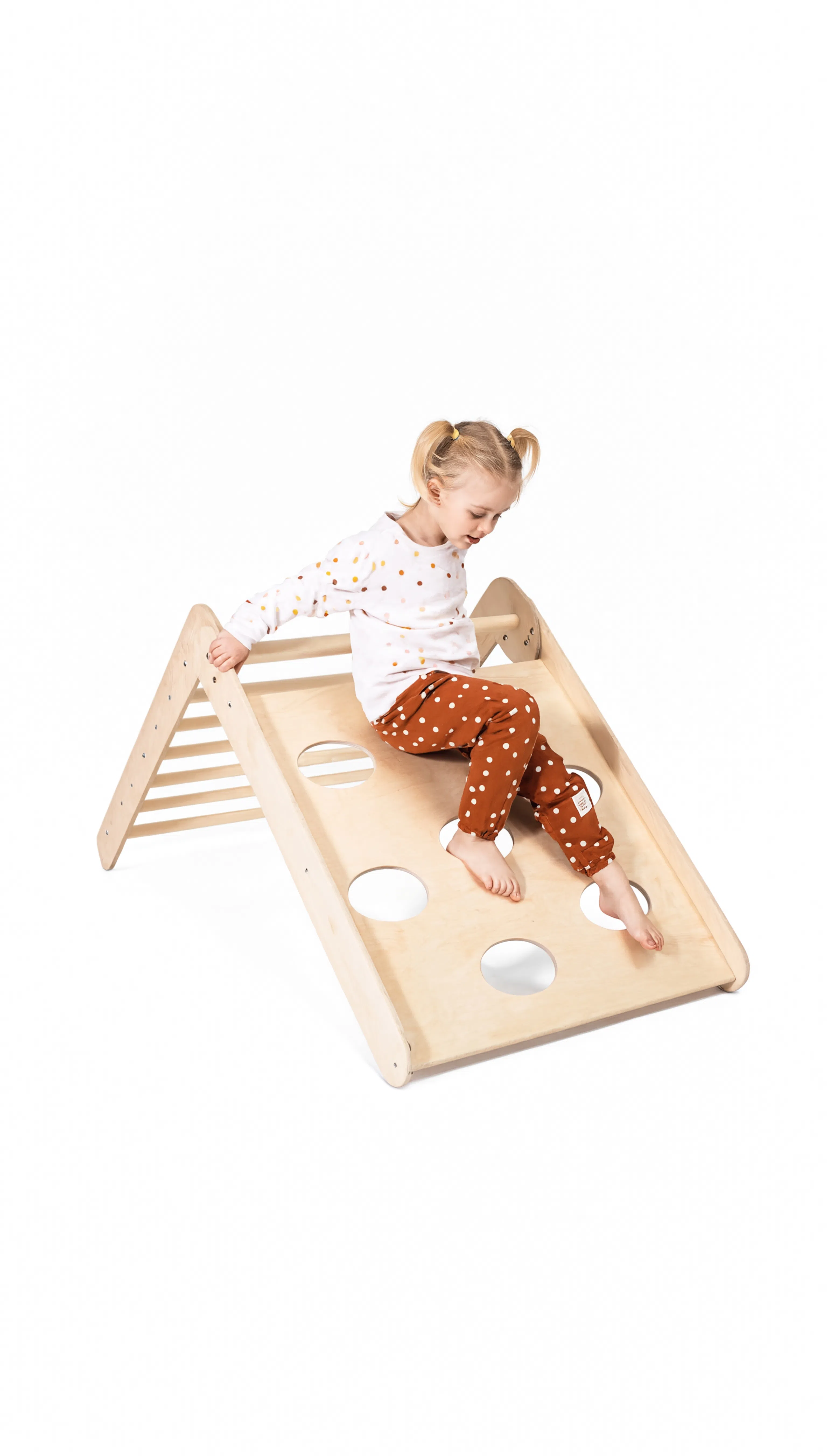 Child playing on a wooden climbing toy with a white background