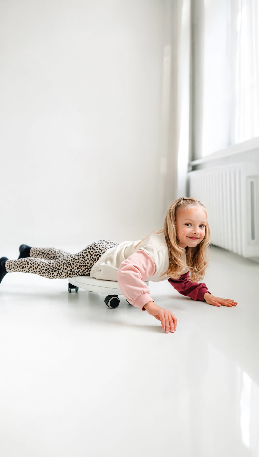 Child playing on a white floor in a bright room