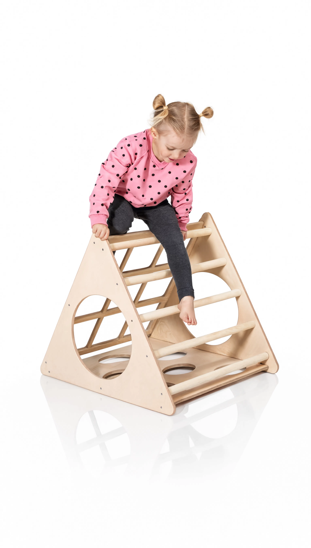 Child climbing a wooden triangle structure on a white background