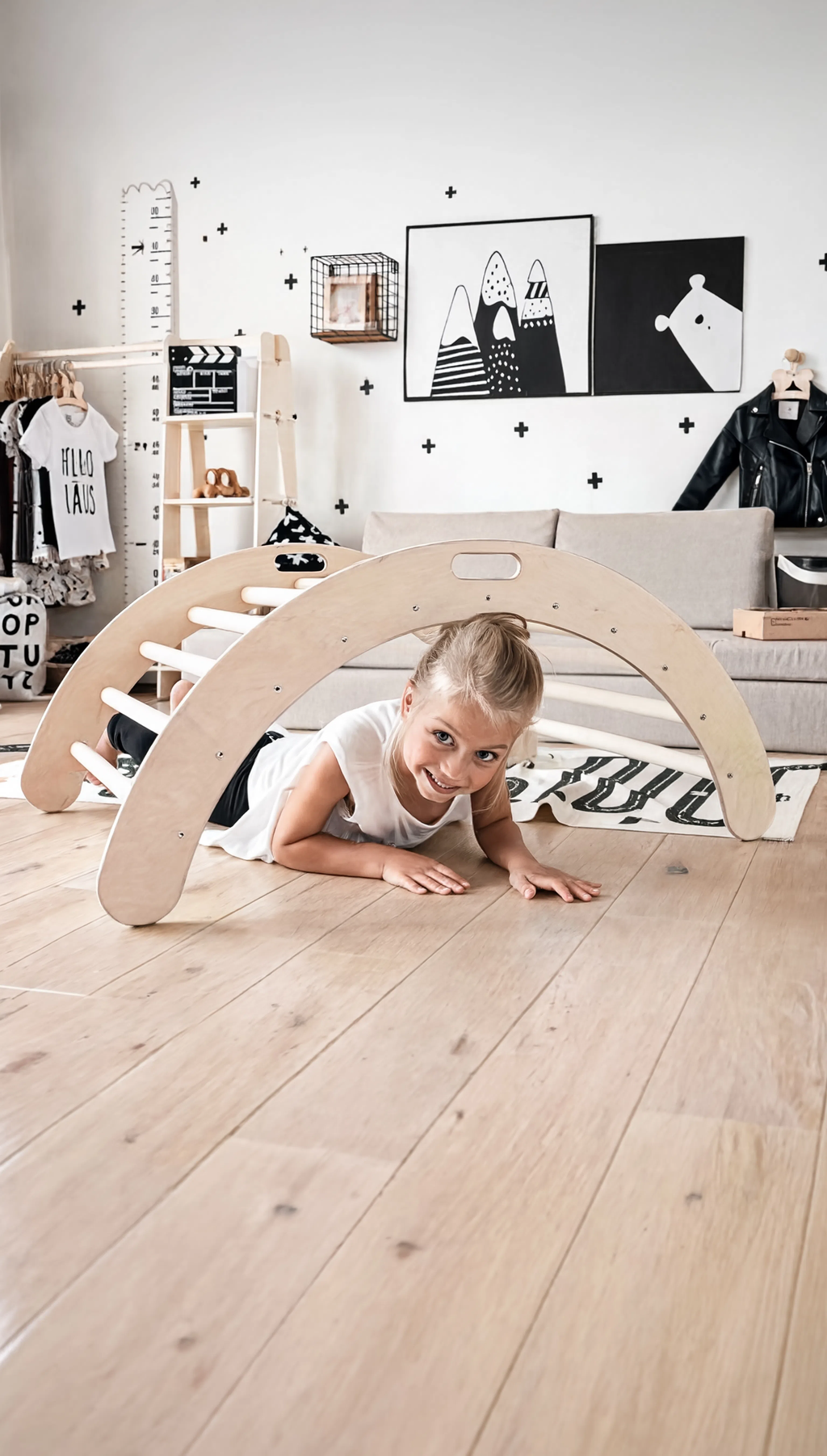 Child playing on a wooden climbing toy in a room with shelves and decor.